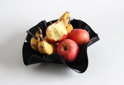 High angle view of fruits in bowl over white background