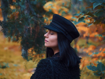 Close-up of woman with eyes closed in park during autumn