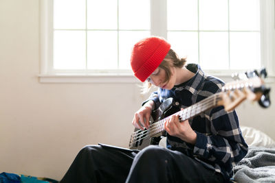 High school student working at home on learning guitar for homework