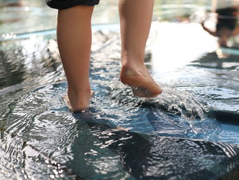 Low section of person standing in water