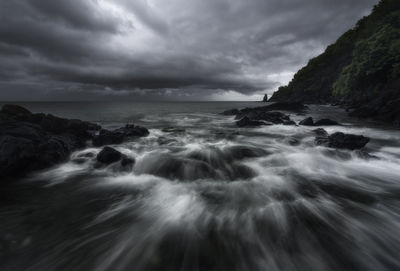 Scenic view of sea against storm clouds