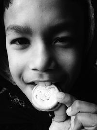 Close-up of boy eating biscuit