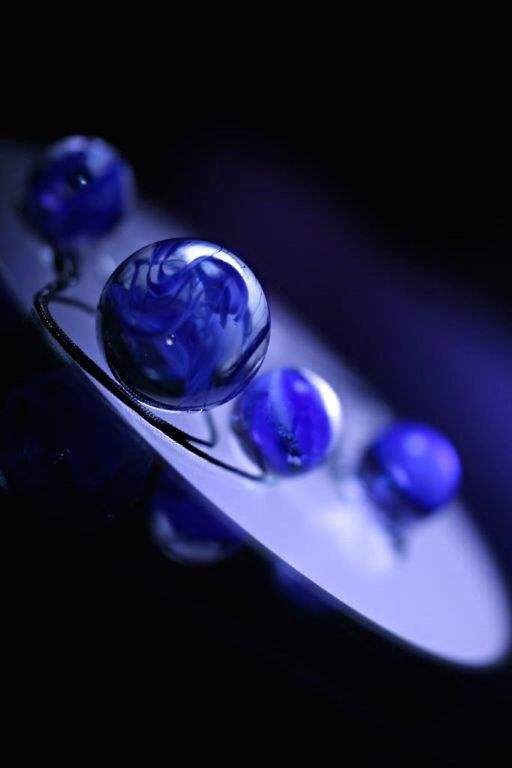 close-up, selective focus, fragility, focus on foreground, studio shot, purple, black background, blue, indoors, drop, purity, freshness, water, still life, sphere, transparent, no people, reflection, bubble, shiny