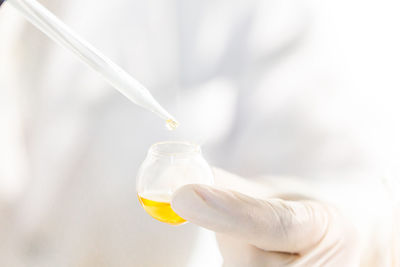 Beauty background, scientist is sampling orange a chemical extract from organic natural, research