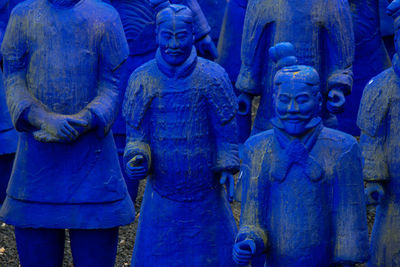 Close-up of buddha statue against blue wall