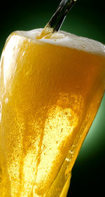 Close-up of yellow glass against orange background