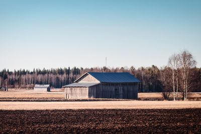 House on field against clear sky