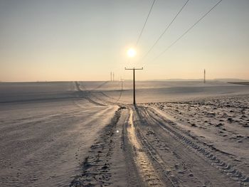 Scenic view of snowy landscape against clear sky during sunset