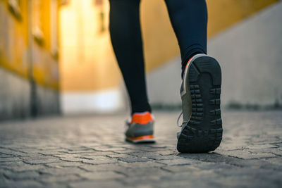 Close up of male feet walking during workout. legs of man run in the city and jogging alone