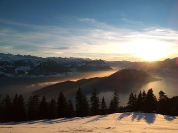 Scenic view of snowcapped mountains against sky during sunset