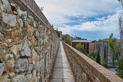 Footpath amidst buildings against sky