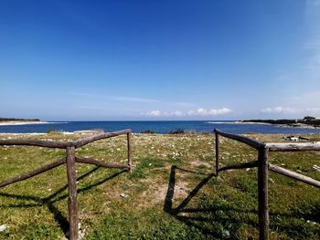 Scenic view of sea against sky seen through fence