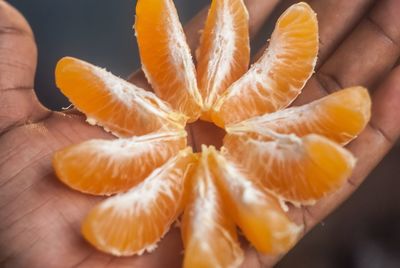 Close-up of hand holding orange pieces