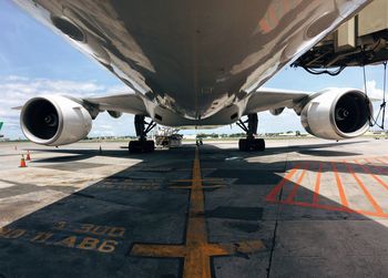 Airplane on airport runway against sky