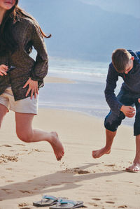 Playful siblings on shore at beach