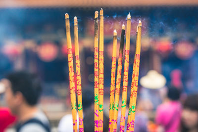 Close-up of incenses burning outside temple
