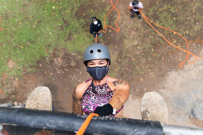 Woman wearing face mask and rappelling on the lapa catwalk in salvador, bahia, brazil.