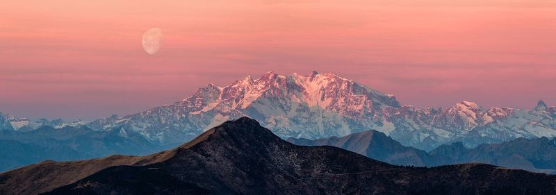 Panoramic view of monte rosa against orange sky in winter