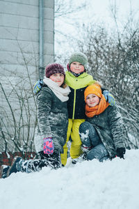 Full length of a boy with sisters in snow