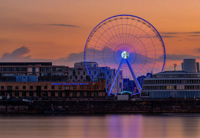Ferris wheel in city at sunset
