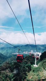 Overhead cable car over sea against sky