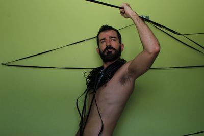 Portrait of shirtless young man against white background