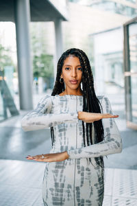 Portrait of beautiful young woman gesturing while standing on floor