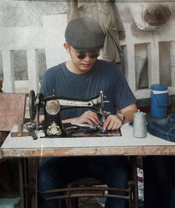 Young man stitching fabric