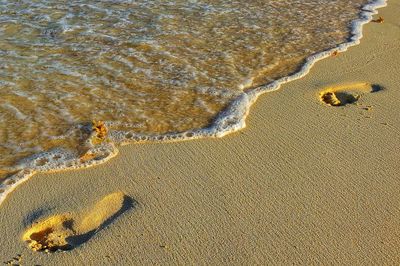 High angle view of footprints on sand at beach