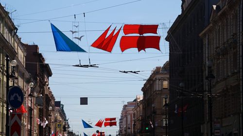 Low angle view of flags hanging amidst buildings in city