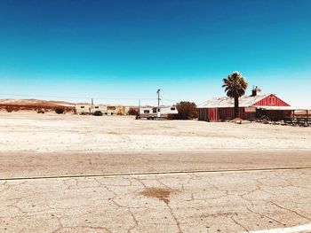Scenic view of beach against clear blue sky