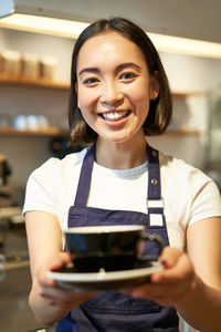 Portrait of smiling young woman using mobile phone