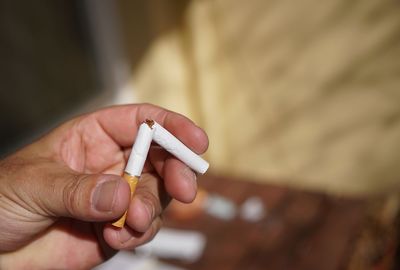 Close-up of hand breaking cigarette