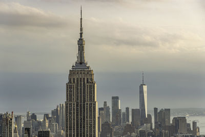 Modern buildings in city against cloudy sky