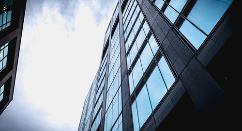 Low angle view of glass building against sky