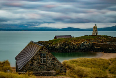 Lighthouse by sea against sky