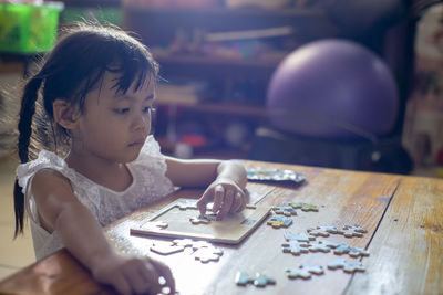 Portrait of girl playing with table