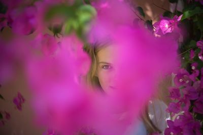 Portrait of woman on pink flowering plant