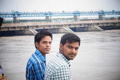 Portrait of male friends by river