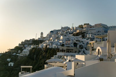 Low angle view of buildings on mountain against clear sky during sunset
