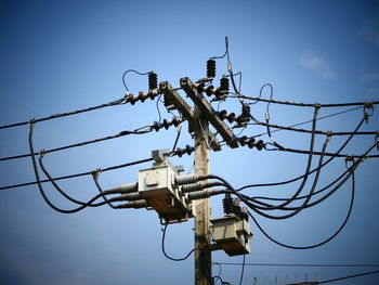 Low angle view of electricity pylon against clear sky