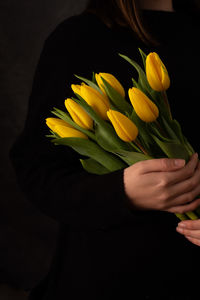 Close-up of hand holding yellow flower