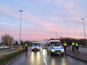 Cars on road against sky during sunset