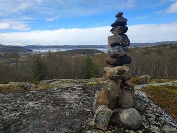 Stack of rocks on land against sky