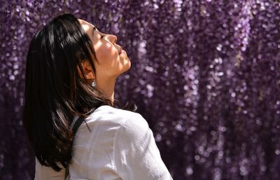 Woman with closed eyes against tree