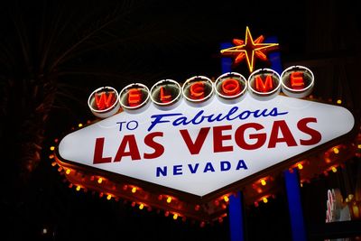 Low angle view of illuminated sign at night