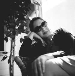 Portrait of woman wearing sunglasses sitting on seat