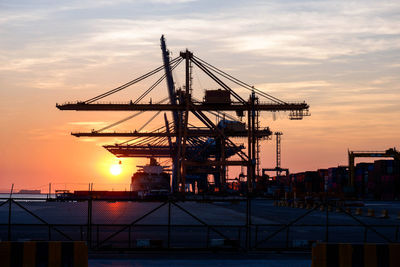 Cranes at construction site during sunset