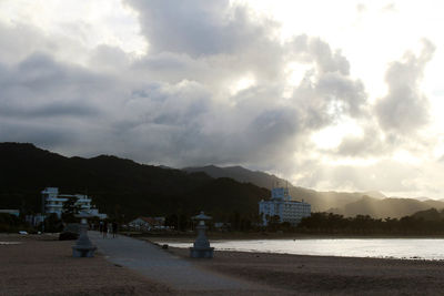 Scenic view of beach by buildings against sky