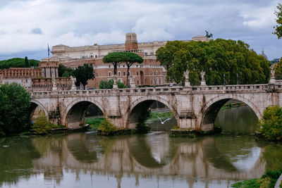 Arch bridge over river against sky